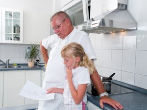 Father and daughter looking at a recipe